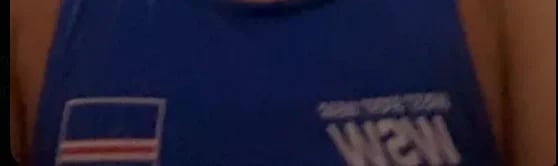 Close-up of blue clothing with American flag patch and partial text visible on fabric